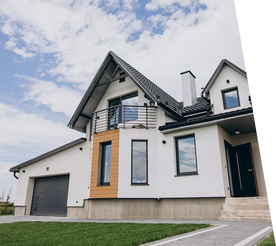 Modern two-story house with a mix of white and wooden accents, featuring large windows and a balcony, set against a cloudy sky.